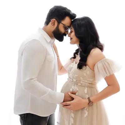 An intimate black and white portrait capturing the quiet connection between expecting parents. Their gentle embrace and shared smiles tell a story of love and anticipation.