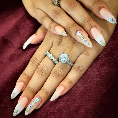 A video showcasing extra-long stiletto nail extensions with a soft ombre base, adorned with carefully placed iridescent crystals for a glamorous bridal look.