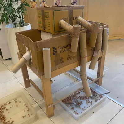 This cardboard contraption is an invitation to explore physics and cause-and-effect. Children can pour beans through the tubes, observing how they travel and collect, turning a simple setup into a science experiment.