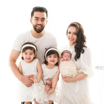 A beautiful family of five. This portrait captures the joy and love as they welcome their newest little princess, surrounded by her adoring big sisters. A perfect family photograph to mark a new chapter.