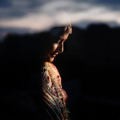A beautiful bridal portrait using reflection and dramatic lighting. This artistic approach creates a soft, ethereal image that highlights the bride's profile.