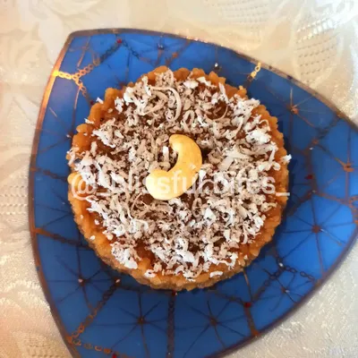 This is my Gur Wale Chawal, or jaggery rice, a classic North Indian dessert. It's garnished with shredded coconut and a cashew, offering a wholesome and comforting sweet flavour.