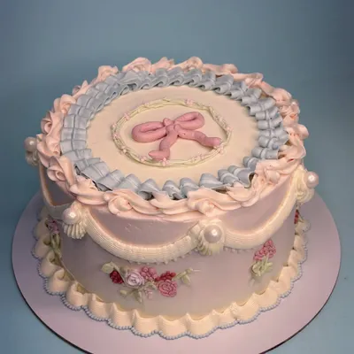 Bringing back all the old-world charm with this ornate Lambeth cake. The delicate blue and pink piping, complete with a bow and sugar pearls, marks the elegance of the occasion.