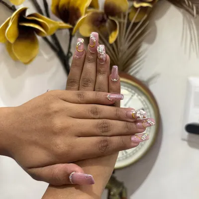 Your hands are always on display, especially during wedding festivities. We offer custom bridal nail extensions and art, like this beautiful set featuring delicate 3D flowers, glitter, and gold accents to perfectly match your bridal ensemble.