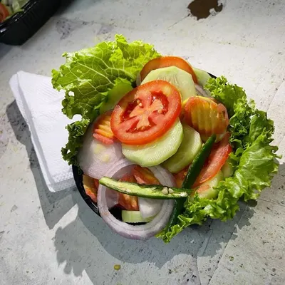 A close-up of the fresh salad I serve with my meals. It includes lettuce, cucumber, tomatoes, onions, and green chili for a refreshing and crunchy side.