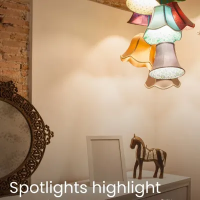 Lighting is the soul of interior design. In this image, the quirky, multi-colored pendant light acts as a statement piece, while spotlights are used to highlight the decor on the console table, creating layers of light.