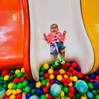 Even our tiniest visitors can enjoy the fun. This little one is having a safe and gentle slide into our colorful ball pit.