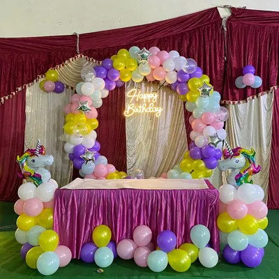 I create magical themed parties for kids, and the Unicorn theme is a favorite. This setup includes a full circular balloon arch in rainbow pastels, a glowing neon sign, and two unicorn-topped balloon pillars to frame the cake table.