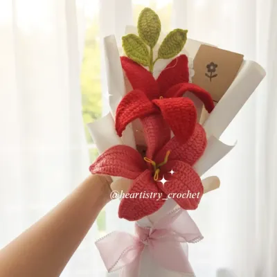 A beautiful bouquet featuring two vibrant red crochet lilies. The details in the petals and the bright yellow stamen make these flowers really stand out.