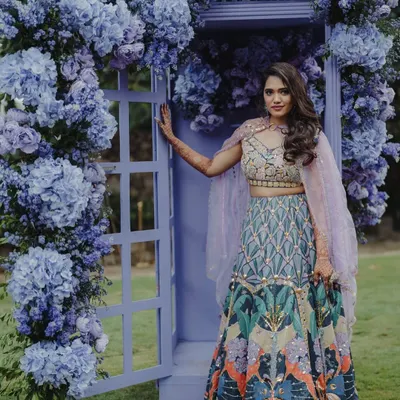 A portrait of the bride by a stunning photo booth I designed. The door is framed with an abundance of purple hydrangeas, creating a whimsical and romantic backdrop for photos.