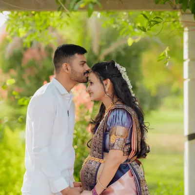A tender moment between partners, celebrating their journey in beautiful traditional attire. This outdoor maternity portrait is filled with warmth and anticipation.