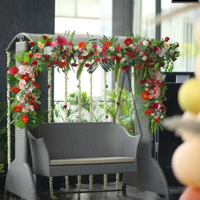 A beautiful floral swing I decorated for a baby shower. The mix of red, pink, and orange flowers with hanging jasmine strings created a perfect, fragrant spot for the mom-to-be.