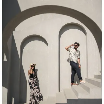 A stylish and modern pre-wedding photo using strong shadows and architectural arches to create a visually interesting and artistic composition.