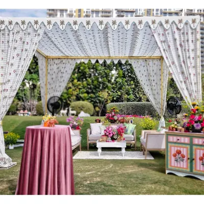 A beautiful lounge area created under a custom-printed tent. We paired comfortable sofas with colorful, hand-painted furniture and fresh flowers to create an inviting space for guests to relax.