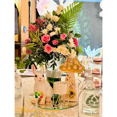 The devil is in the details. For this whimsical party, the table centerpieces included fresh floral arrangements, a cute rabbit figurine, and a themed mushroom prop, all coming together to create a magical tablescape.