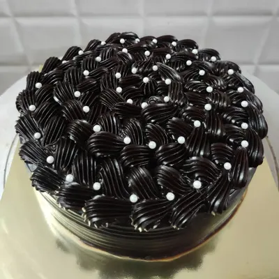 I love the challenge of creating detailed frosting designs. This rich chocolate cake features an intricate basket-weave piping technique, with each swirl carefully placed and dotted with delicate white pearls for an elegant finish.