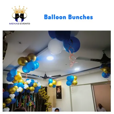 For this home birthday celebration, I used balloon bunches in blue, gold, and white to decorate the ceiling. This is a simple but effective way to add a festive touch to the entire room.