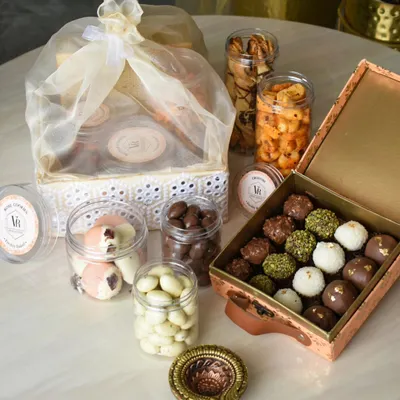 This is what a celebration looks like in a box. My custom Diwali hampers are designed to be a complete experience, featuring an assortment of my signature chocolate truffles, jars of savory and sweet nuts, and a traditional diya to light up the festivities.