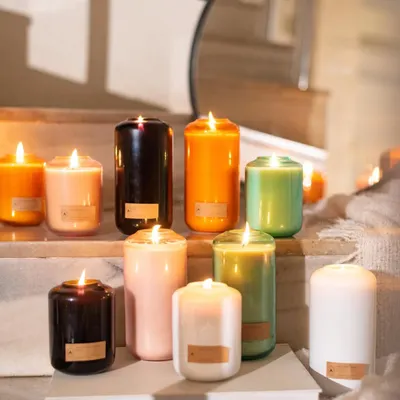A home is complete with a beautiful candle, and this image showcases my limited edition Volumetric Curve collection. The variety of colors and sizes creates a stunning display, adding warmth and style to this home's staircase.