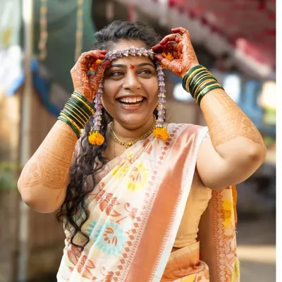 This is the moment of pure happiness. I love capturing the bride as she places the mundavalya on her head during the haldi ceremony, a beautiful Maharashtrian wedding tradition. Her smile here is so genuine and full of excitement for what's to come.