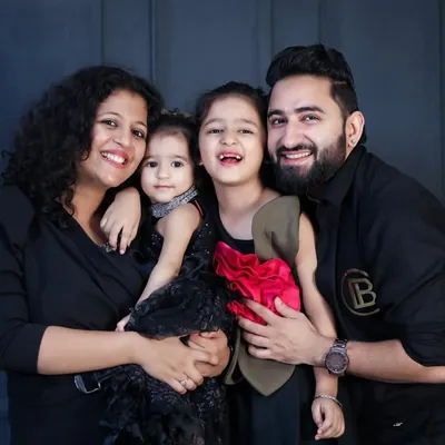 A classic family portrait that radiates happiness. In the studio, with a simple background, all the focus is on your family's smiles and connection. This beautiful family of four shows how timeless these photos can be.