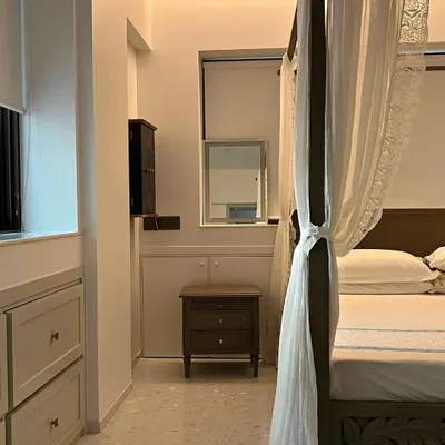 A glimpse into a serene bedroom from our Bandra bohemian project, featuring a classic four-poster bed with delicate drapery that creates a soft, romantic atmosphere. The terrazzo flooring adds a touch of modern texture.