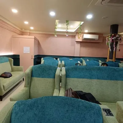 A view of the seating area in the Howrah station lounge. The colour scheme combines soft pink and a deep teal half-wall to create a space that is both soothing and professional.