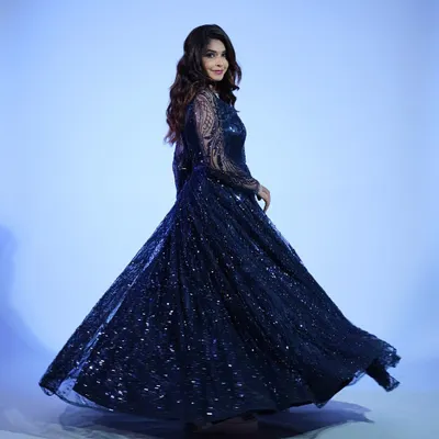 A full-length shot of the midnight blue sequin gown. The way it flows and sparkles is perfect for making a dramatic entrance at any formal event.