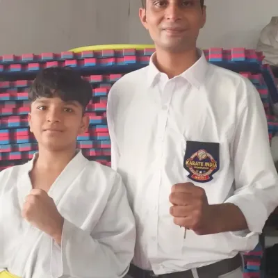 With a young yellow-belt student in the dojo. I am personally invested in the growth of every student.