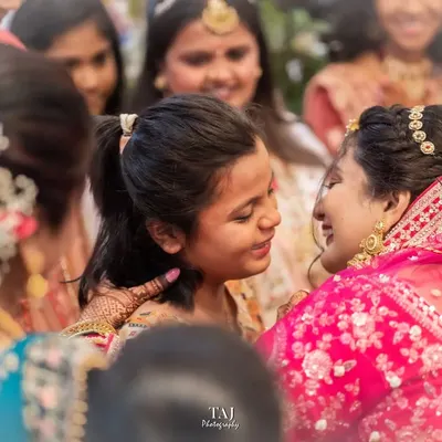 A tender moment between the bride and a younger family member during the Bidai. These are the emotional, unscripted goodbyes that are so important to capture.