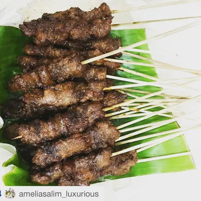 A close-up of my Sate Babi, laid out on a traditional banana leaf. You can see the rich color from the marinade and the perfect char from the grill. Each bite is packed with authentic Indonesian flavor.