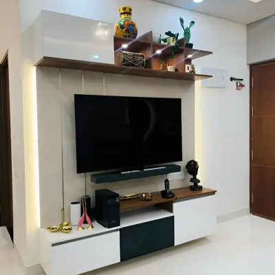 This modern TV unit features a high-gloss white finish paired with dark wood accents. The asymmetrical shelving adds visual interest, while vertical side lighting enhances the contemporary look.