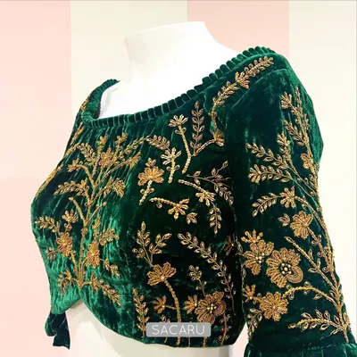 Green velvet and gold zardosi embroidery is a combination that never goes out of style. This blouse features a wide neckline and full-sleeve floral embroidery.
