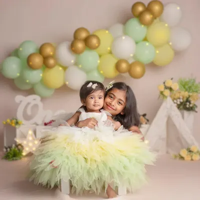 Sisters for life and beyond! This beautiful portrait of two sisters in matching dresses captures the sweet and playful bond they share.