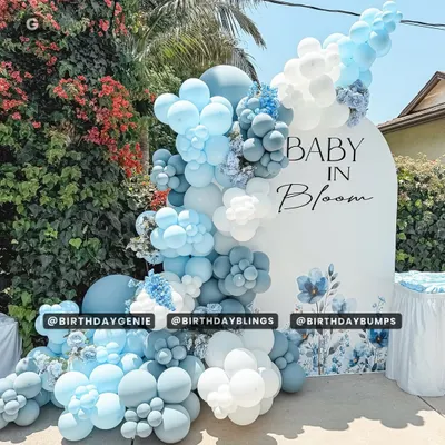 A beautiful outdoor "Baby in Bloom" baby shower, featuring a stunning balloon cascade in shades of blue and white with floral accents.