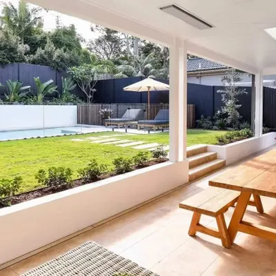 This view shows a covered patio with a dining area that steps down to a lawn and poolside lounge. I use raised planters to create layers and separate the different functional spaces.