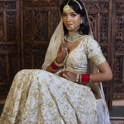An elegant and modern bridal look featuring an ivory and gold lehenga. The simplicity of the jewellery and the soft makeup make this a very sophisticated shot.