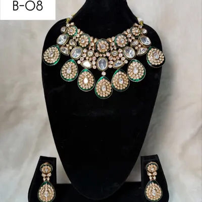 My bridal set B-08 is a bold choker featuring large, teardrop-shaped polki stones with green meenakari work. The matching earrings complete this regal rental set.