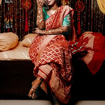 A full-length shot of a bride showcasing her complete henna look, with intricate designs on both her hands and feet, perfectly coordinated for her wedding day.