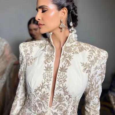 A close-up of the radiant skin and intricate braided hairstyle I designed for the Manish Malhotra Bridal Couture Show. The makeup features a strong highlight and contoured cheeks to accentuate the bone structure under the show lights.
