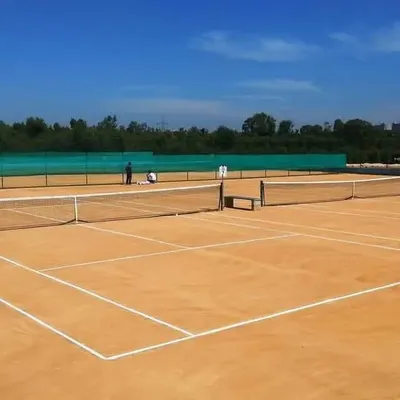 A wide-angle shot of our well-maintained clay courts, showcasing the clean playing surface and serene, green surroundings. This is an ideal space for anyone looking to reserve a tennis court in Bangalore.