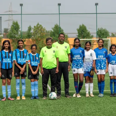 Our U13 girls' squad stands with their coaches, ready to learn and grow. We focus on building a strong foundation for their football careers.