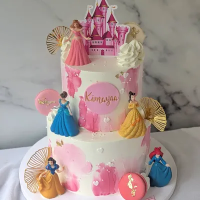 Every princess deserves a castle. This royal two-tier treat for a little princess features a castle topper and several Disney princesses, decorated with pink watercolor buttercream.