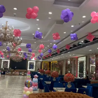 For Kridha's first birthday, I transformed this large banquet hall with a princess theme. I used floating clusters of pink and purple balloons across the ceiling to create a magical atmosphere for the celebration.