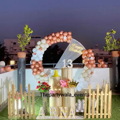 A stunning rooftop party with a rose gold and white balloon ring. The setup looks incredible against the evening sky, perfect for a stylish 13th birthday celebration.
