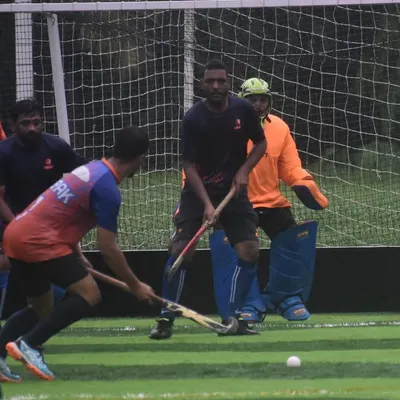 An attacker prepares to take a shot while the goalkeeper holds his position. This drill focuses on the duel between shooter and keeper, a critical moment in any hockey match.