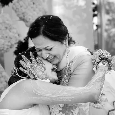 A daughter's emotional embrace with her mother during a Haldi ceremony. This black and white photo freezes a moment of pure, unfiltered love and connection between generations.