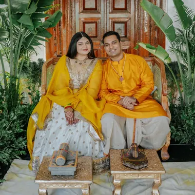 For Ridhi and Prashanth's Haldi, we embraced the venue's natural beauty. Using the vintage door as a backdrop and adding layers of greenery, we created a minimalistic and elegant theme that allowed the couple's "yellove" to shine.