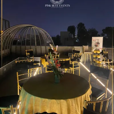 This image showcases an elegant outdoor setup for a corporate evening event. The combination of chic seating, beautiful table linens, and the unique rooftop ambiance provides a sophisticated setting for your team to connect.