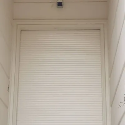 Here is a security sensor installed above a shop's rolling shutter. This is a key part of my wireless alarm system for businesses. If anyone tries to open the shutter after hours, the alarm will trigger and you get an instant call and SMS on your phone.